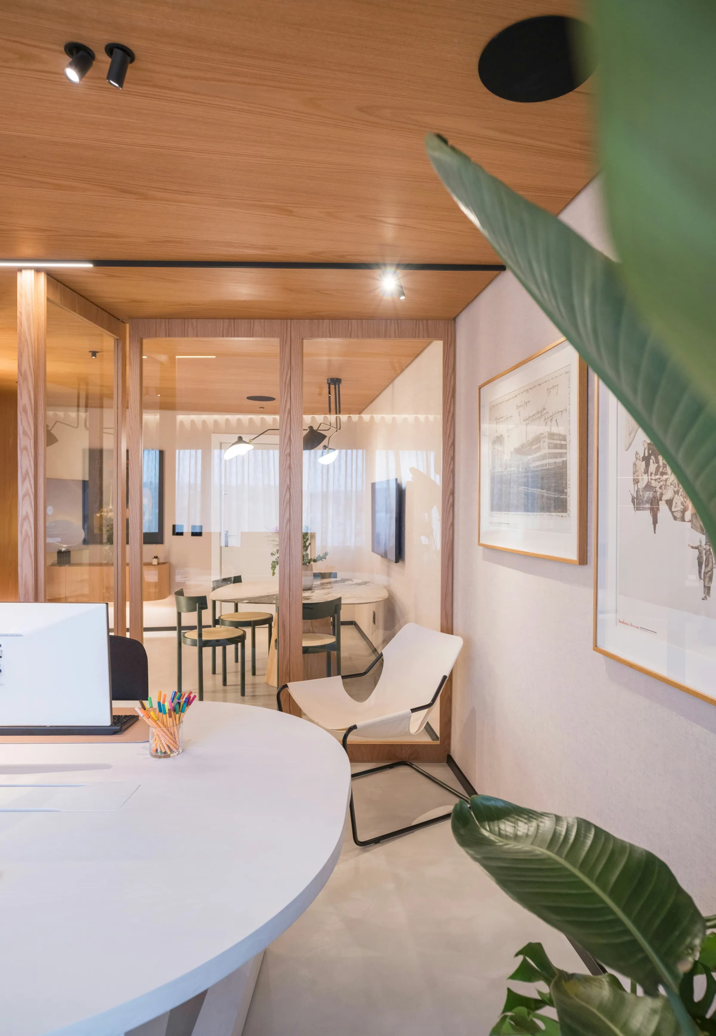 A light-filled office with a desk and glass meeting room